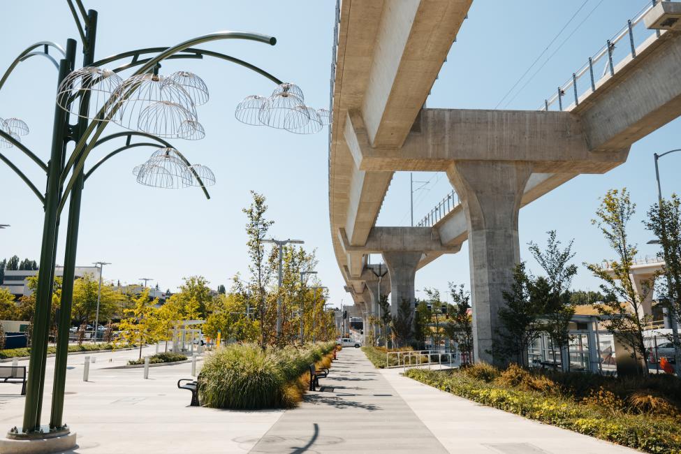 A tall sculpture that looks like a flower is seen next to the elevated tracks near Northgate Station.