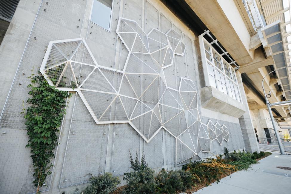 A metal sculpture made up of various shapes sits on a wall near Northgate Station.