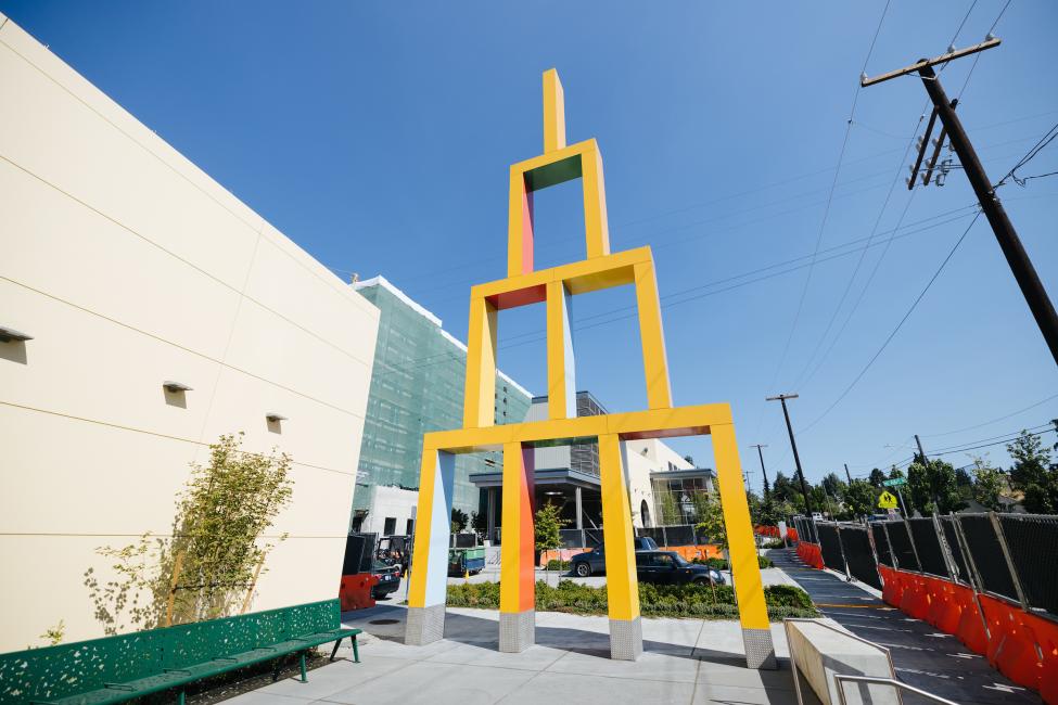 A large yellow sculpture outside Roosevelt Station resembles building blocks.