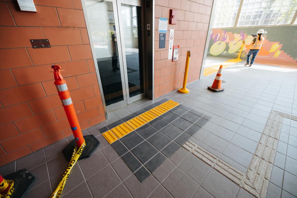 The floor of Roosevelt Station features a bar tile to help people with canes find their way around, including to the elevators and platform.