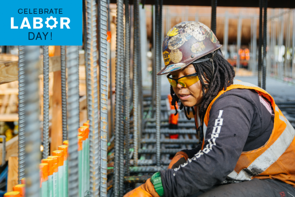 A woman wears a hard hat on a construction site.