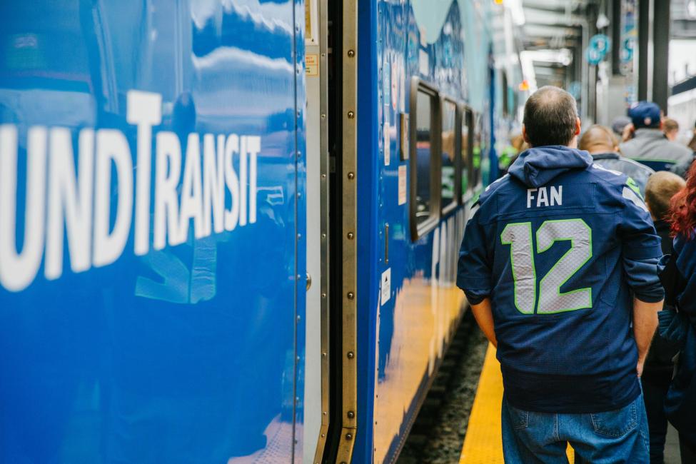 A Seahawks fan walks next to a Sounder train.