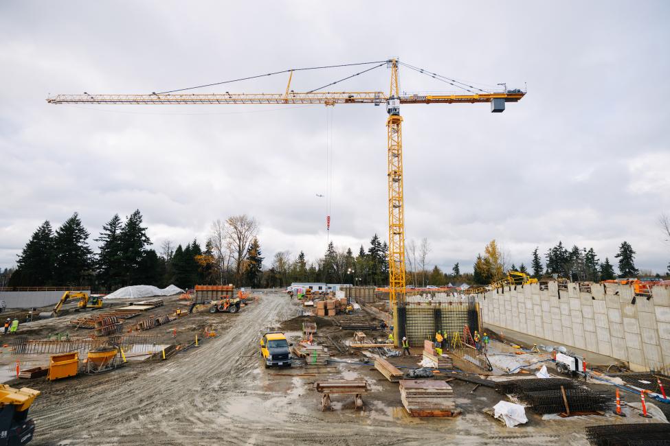 A yellow crane looms above a construction site. 