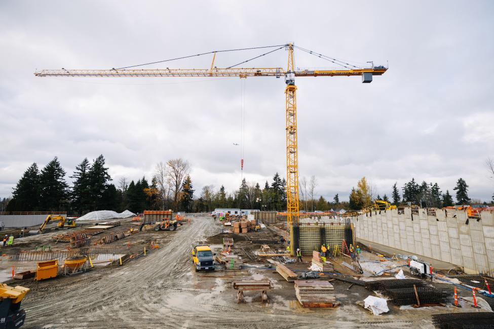 A yellow crane looms above a construction site. 