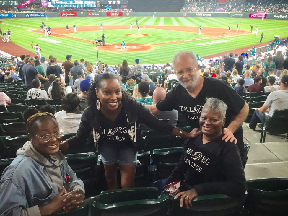 LaTonya Kadar and family smile while watching a Mariners game.