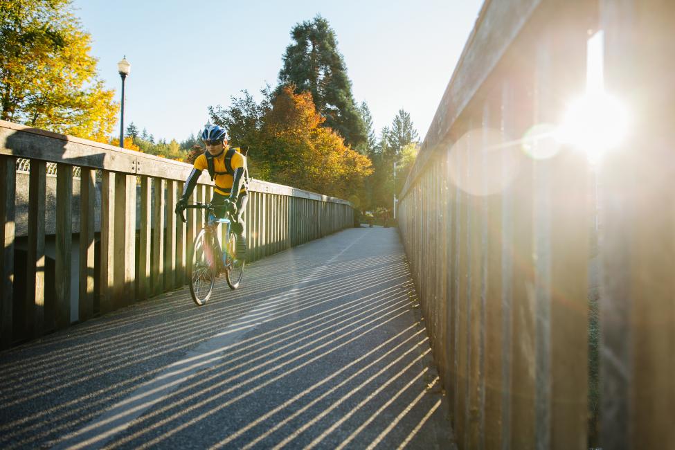 A bicyclist crosses a bridge. 