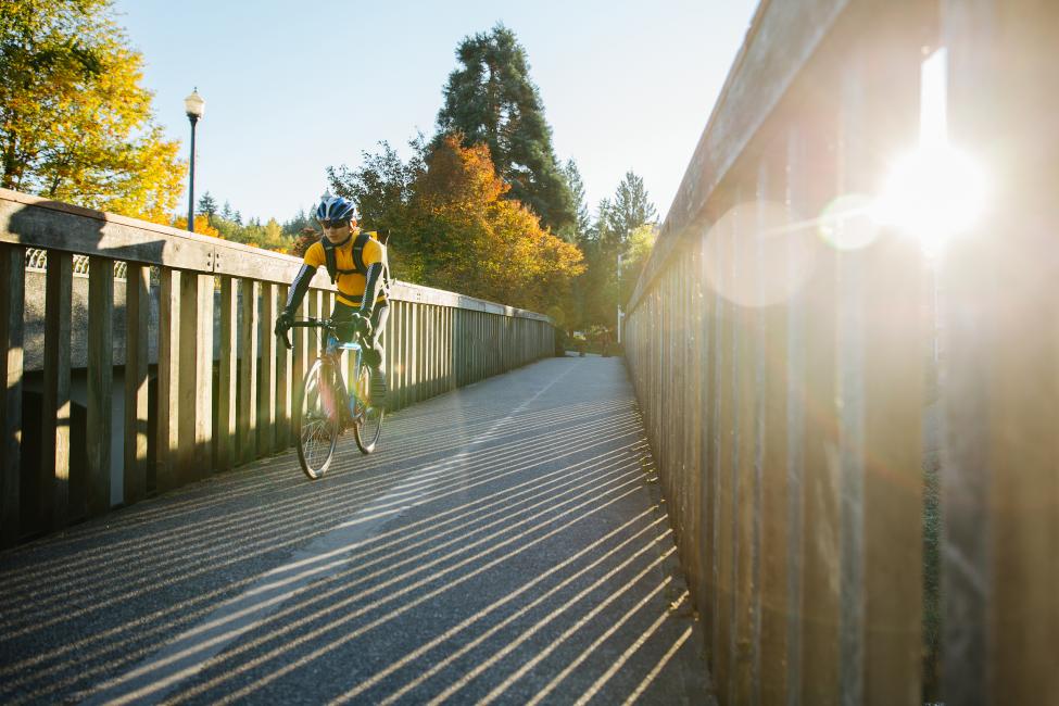 A bicyclist crosses a bridge. 