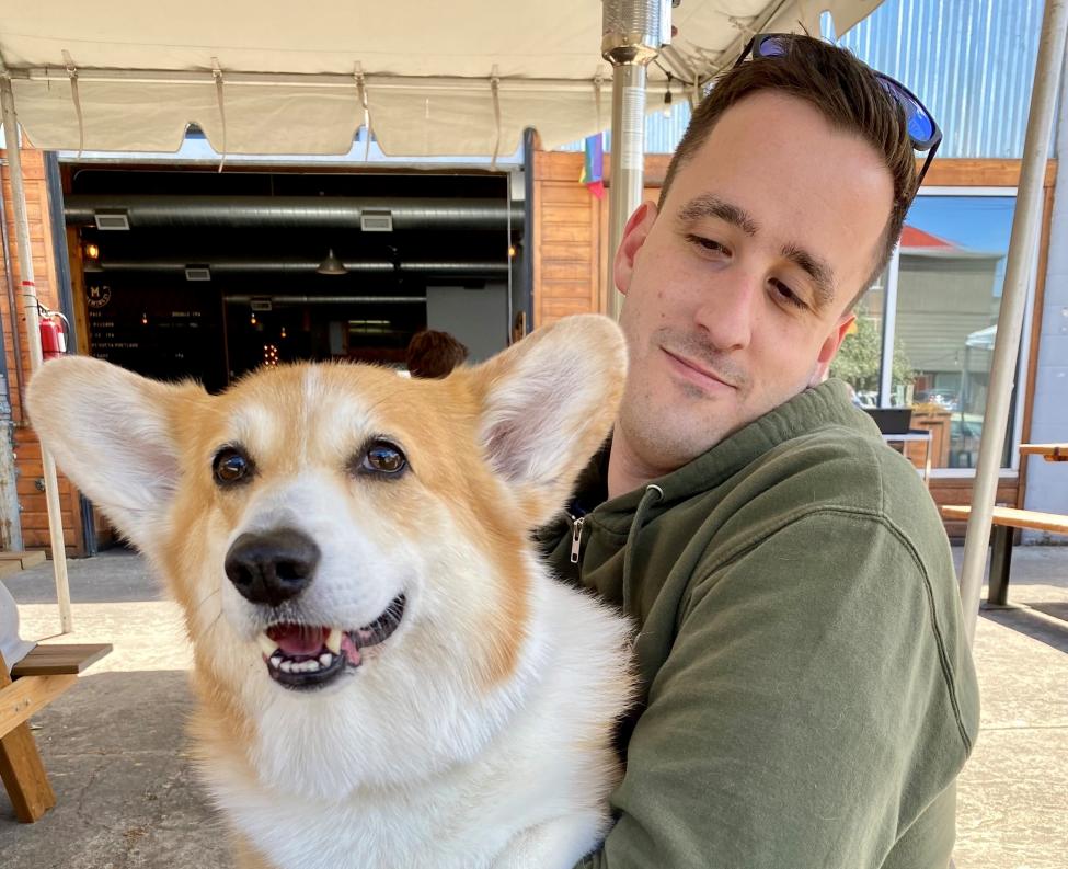 Zack Ambrose holds his corgi, Buster.