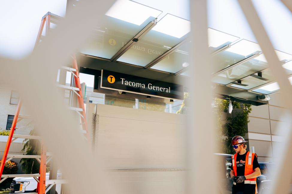 Looking through the art piece at the signage for Tacoma General Station.