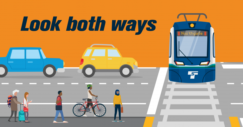 An illustration showing a train approaching a street crossing with vehicles, bike riders and walkers waiting.