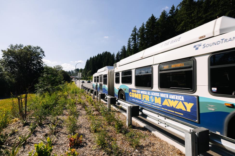 An ST express bus drives away from the camera on a sunny day.