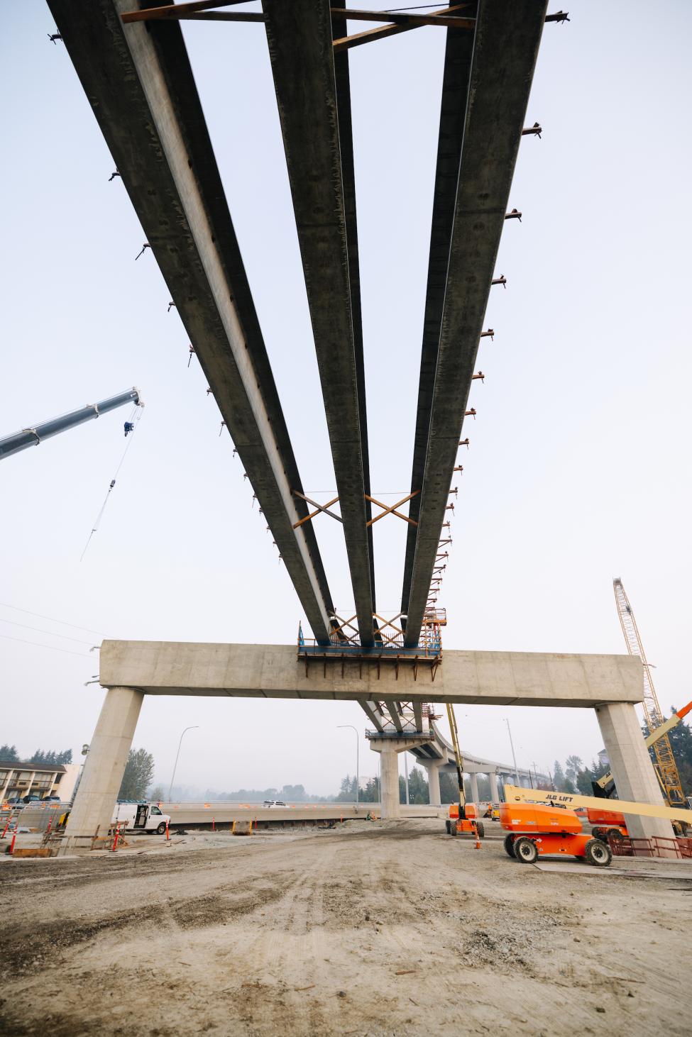 Looking up at girders and elevated guideway under construction for the Federal Way Link Extension. 