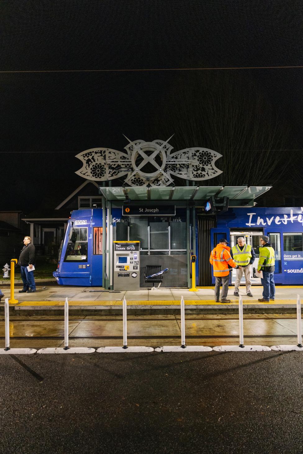 A blue T Line car pulls into the new Tacoma General Station at nighttime. 