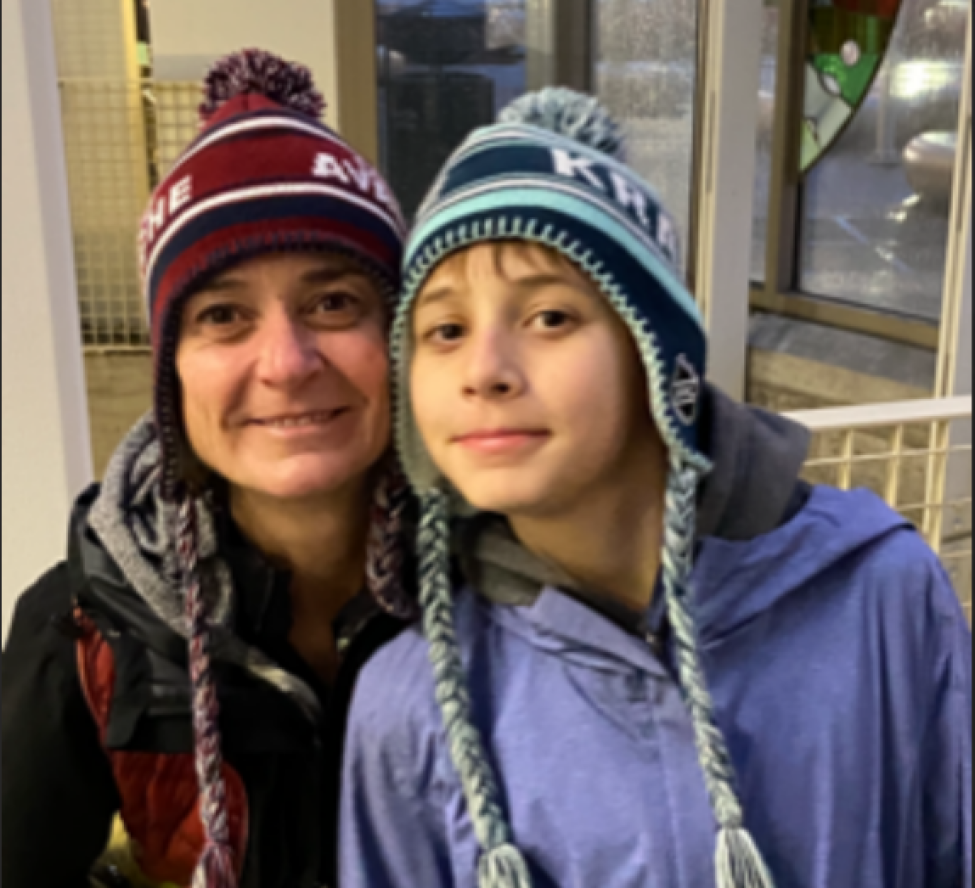 Clara O'Brien and her son smile while wearing wool hats and coats. 