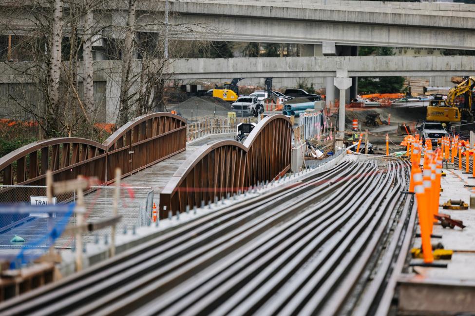 Rows of rail along the road and construction equipment.