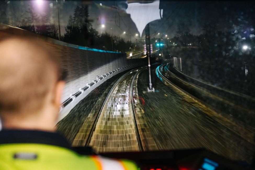 An operator looks out from the cab of a light rail vehicle at tracks in Bellevue.