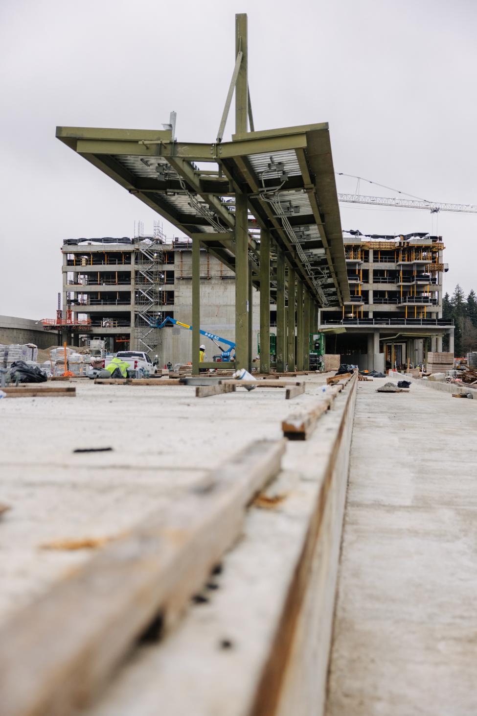 A light rail platform under construction, with a parking garage behind it.