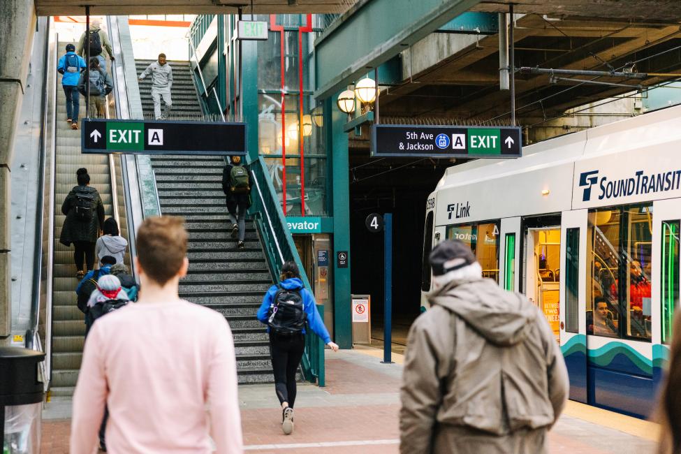 Passengers take an escalator out of International District/Chinatown Station.