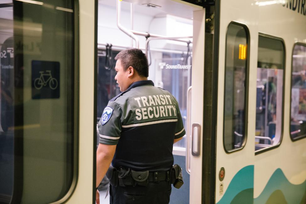 A Sound Transit Security Officer boards a 1 Line train