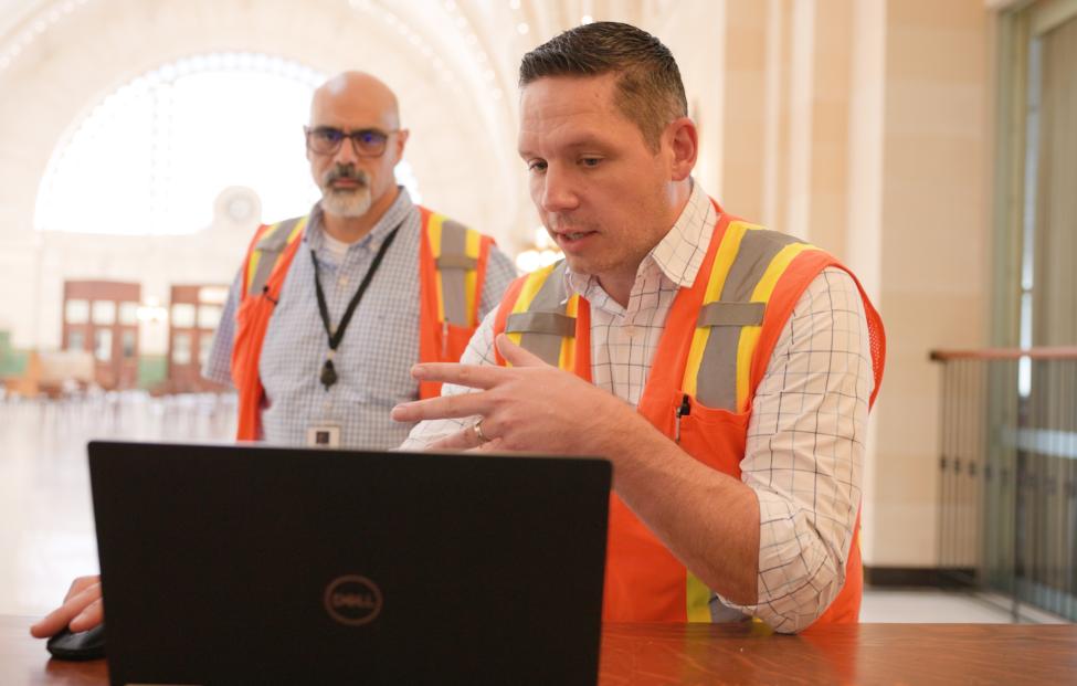 Two Sound Transit employees look at a laptop