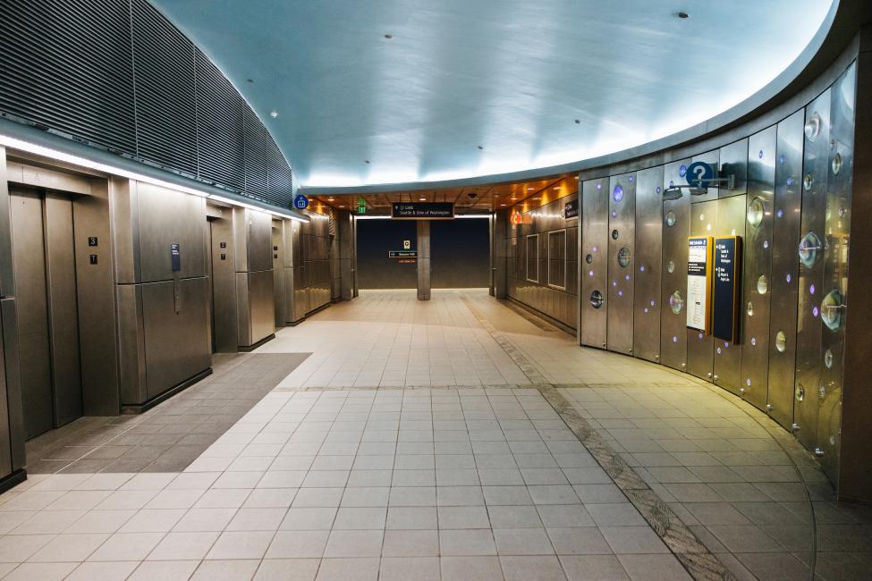 The platform level of Beacon Hill Station, with elevators on the left and art and signage on the right