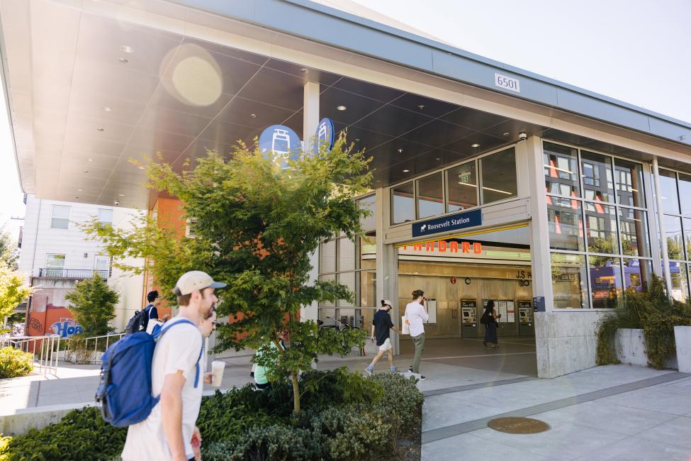 The exterior of Roosevelt Station with a person walking by on the sidewalk.