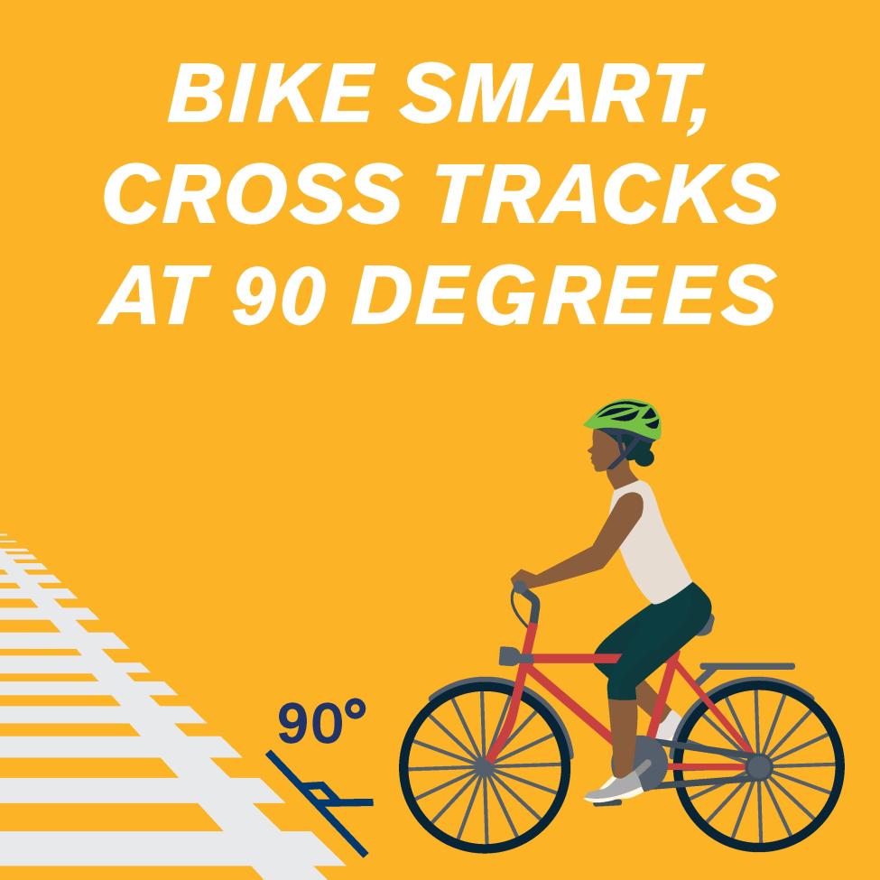 A graphic of a bicyclist crossing train tracks at a 90 degree angle