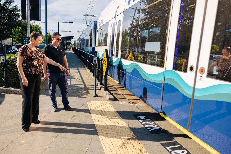Sound Transit CEO Julie Timm points at the new 'look' pavement signage on a Link platform