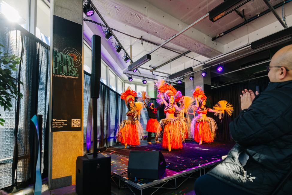 Dancers in orange costumes perform in a new space at Angle Lake Station, called the Roadhouse