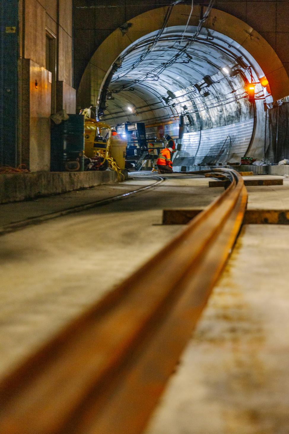 A close up shot of a rail, with the tunnel opening in the background