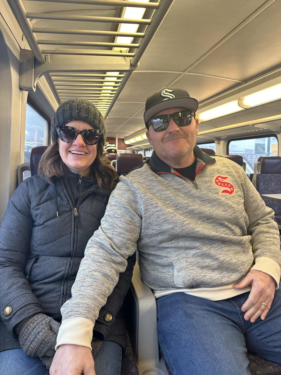 Hannah's parents wear hats, coats and gloves while sitting on the Sounder train.