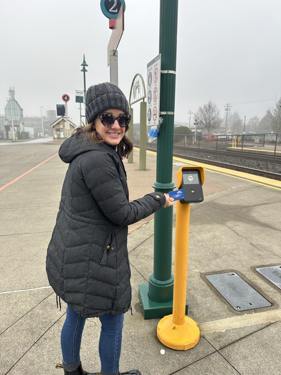 Hannah's mom taps her ORCA card on a yellow reader.