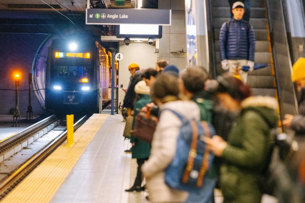 People wait on a platform for an approaching Link train