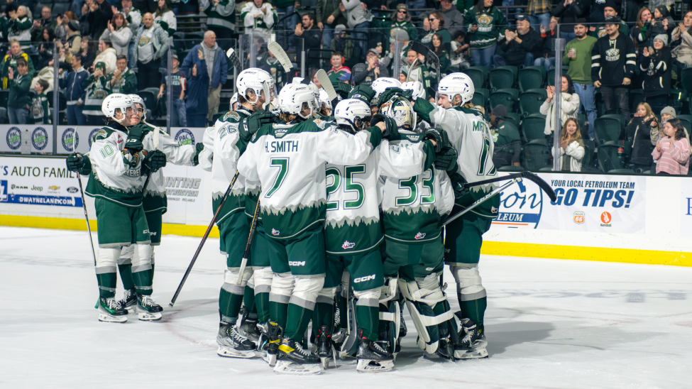 A group of Everett Silvertips huddle together as they celebrate a goal.