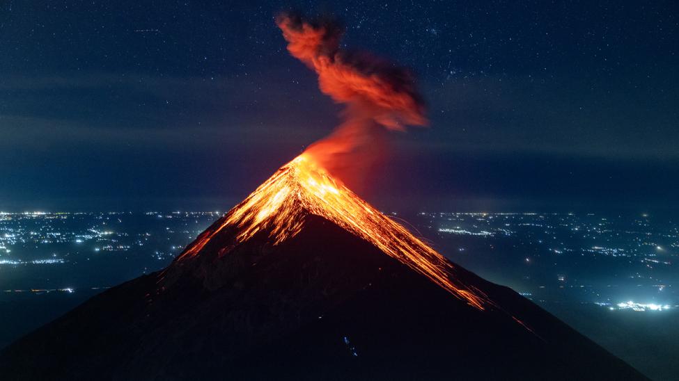 landscape shot of a volcano erupting.