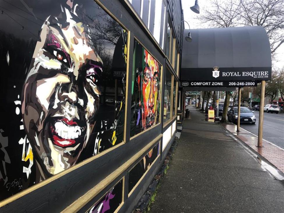 The walkway leading to the storefront of The Comfort Zone featuring a mural of a smiling Black woman.