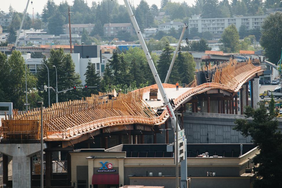 The bridge over 1-405 with lots of orange construction tape and equipment