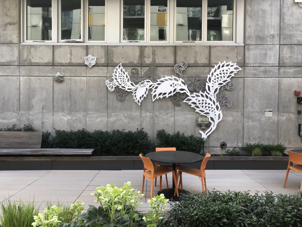 Empty outdoor seating next to an aquatic themed art installation