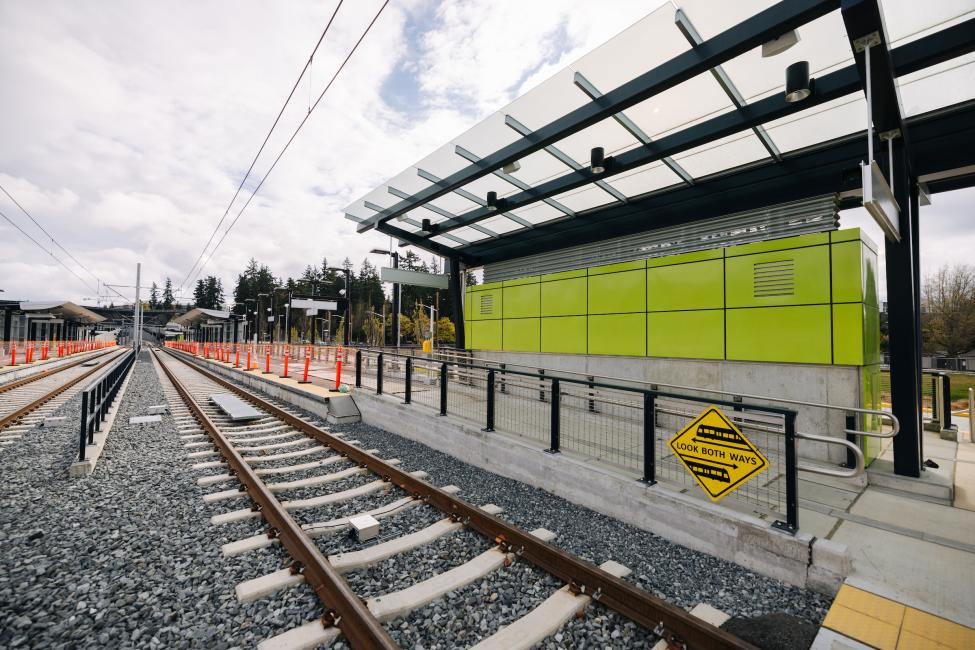 A sign reminds people to look both ways before crossing the tracks at the mostly complete Overlake Village Station.
