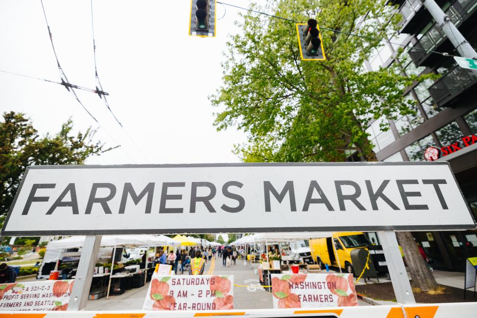 A large black and white sign reads "Farmers Market"