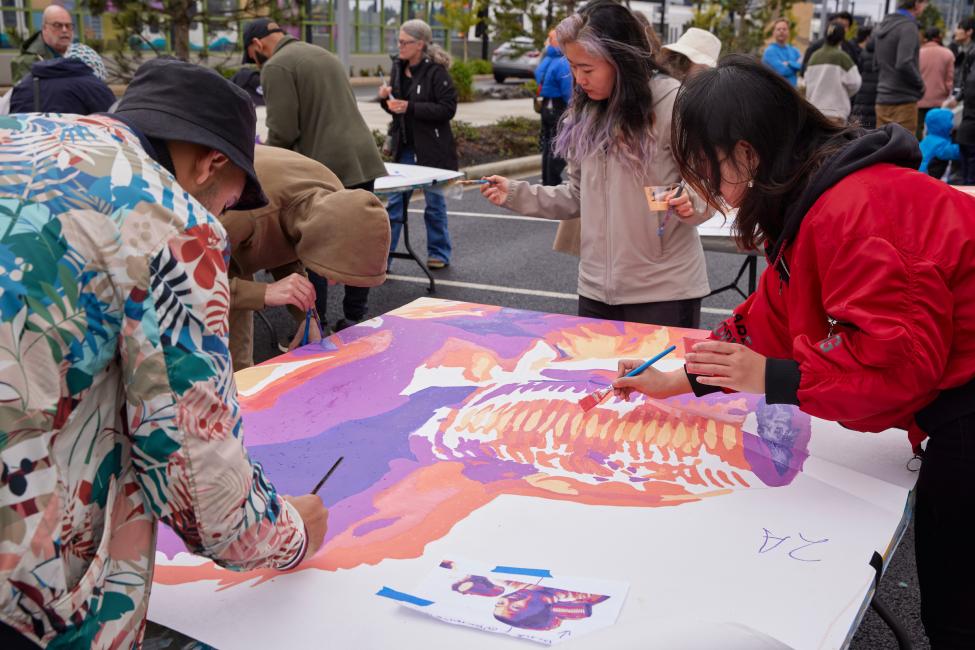Passengers help paint a community mural at BelRed station