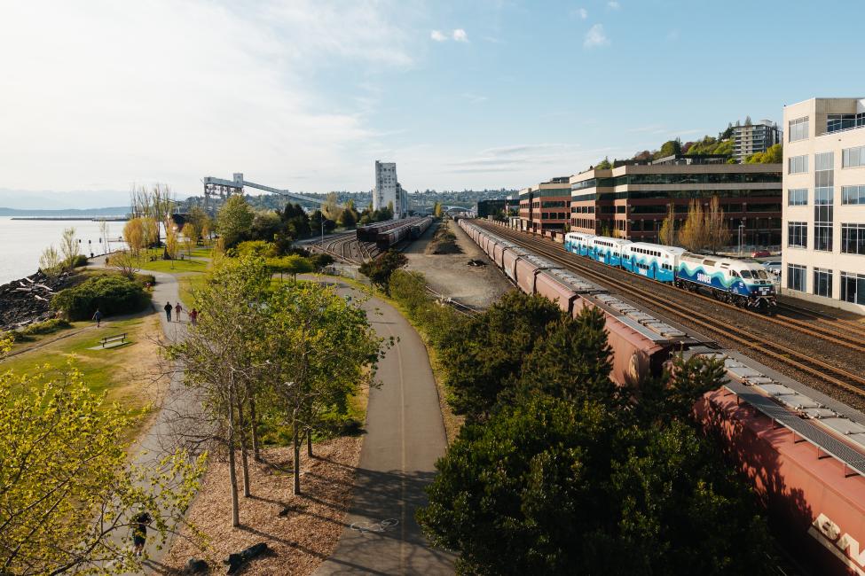 Looking north with Elliott Bay on the left and train tracks on the right with a Sounder train traveling along