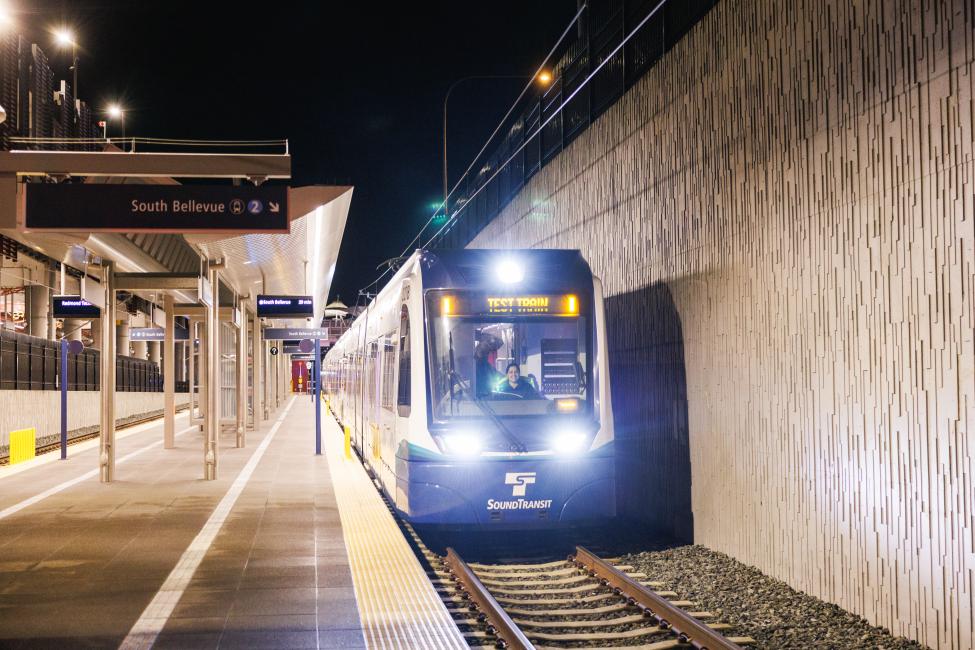 An operator drives a light rail vehicle during nighttime testing in Redmond. The headsign reads "test train"