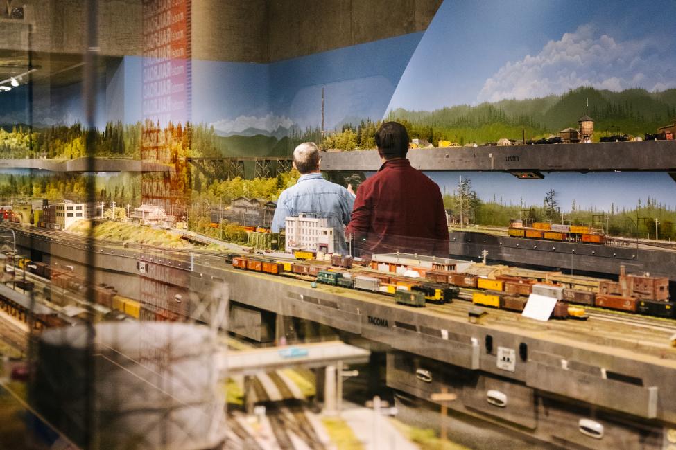 Two people look at a model train display at a museum in Tacoma