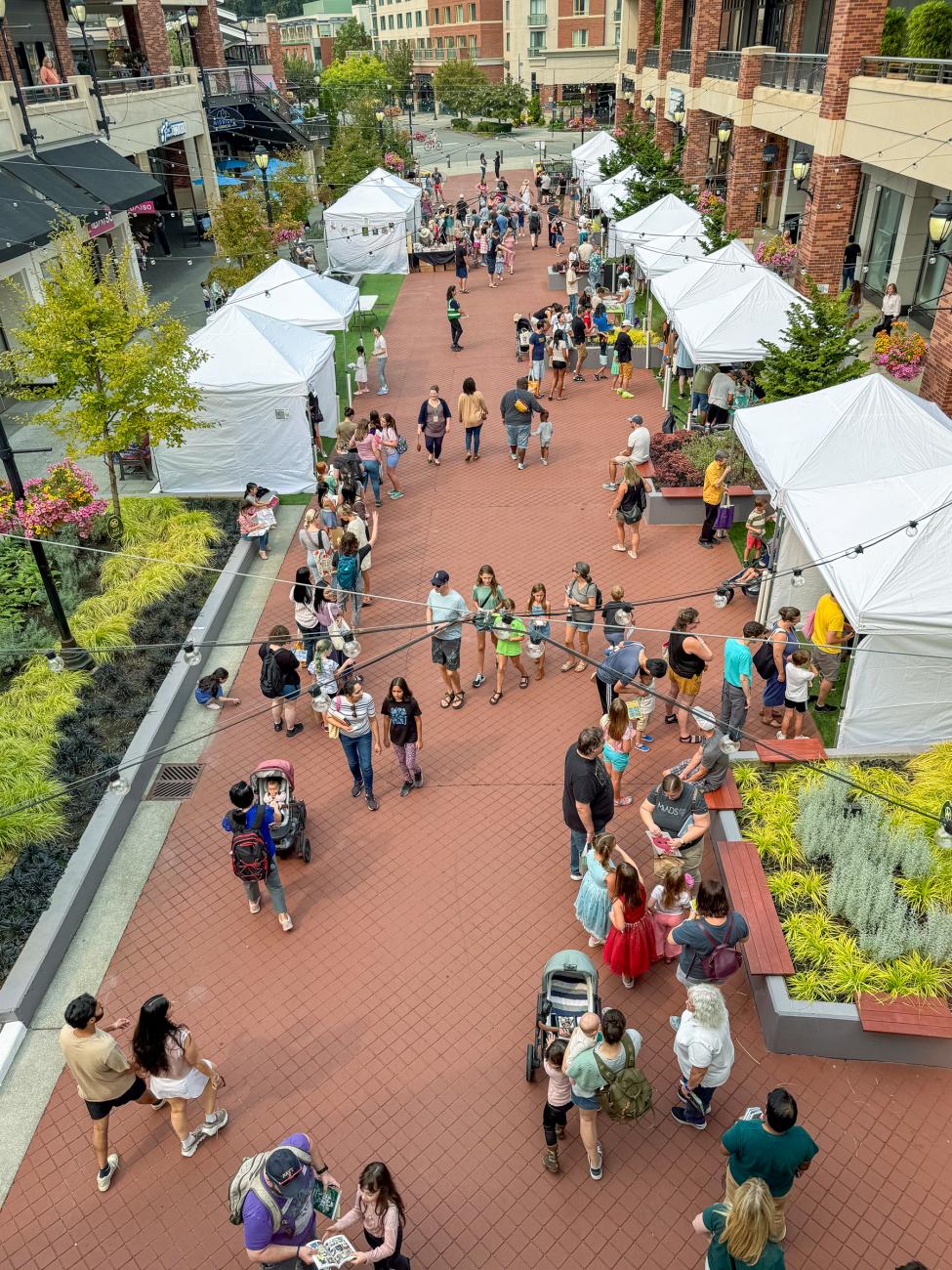 Pop up tents line a plaza as patrons visit each one at Redmond Town Center