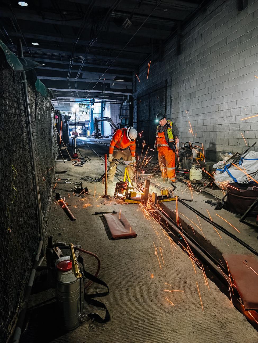 Workers grind a thermite weld on replaced rail in the Downtown Seattle Transit Tunnel on April 21, 2025, near the end of the service disruption.