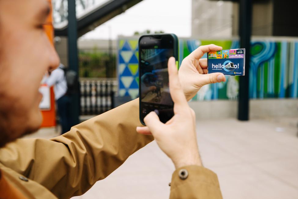 A passenger takes a photo of their Downtown Redmond Commemorative ORCA card