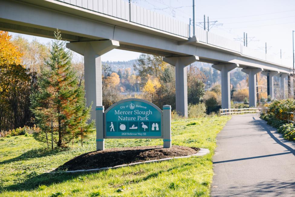 A shot of the light rail tracks in the background of a Mercer Lough Nature Park sign