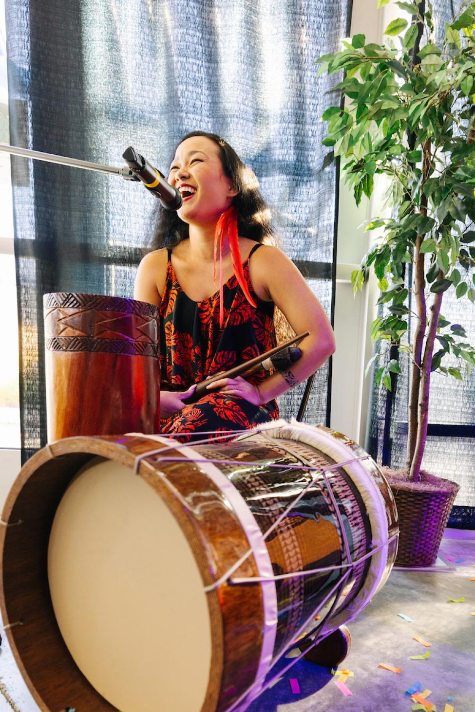 A drummer plays and sings into the microphone