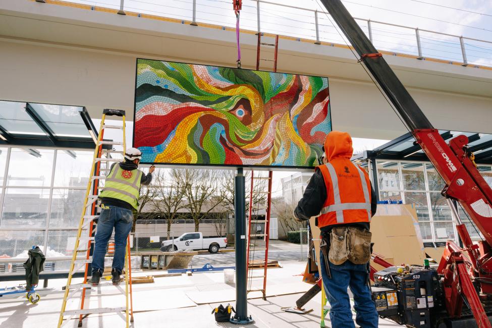 One of the pieces of mosaic art, by Angelina Villalobos, is installed by workers with a crane.